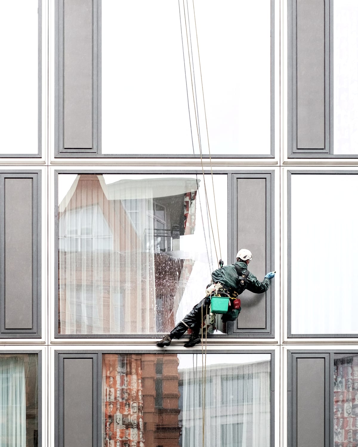Window cleaners working across a building's glass facade